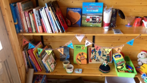Ein Regal mit verschiedenen Gegenständen, unter anderem Büchern und Kinderspielzeug